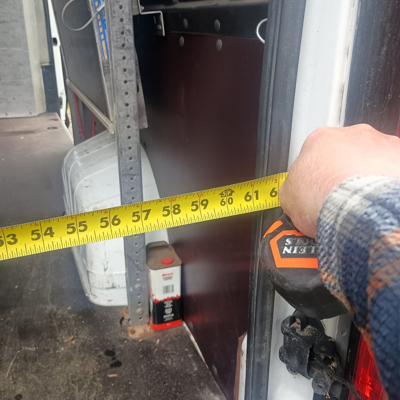 Tape measure showing 61 inches across the rear door opening of a RAM ProMaster 3500