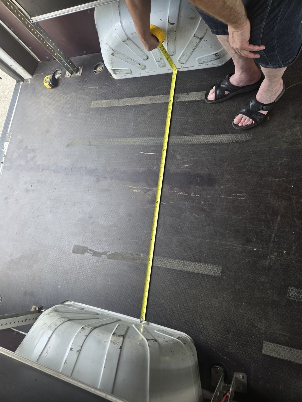 Tape measure between the two rear wheel wells inside the cargo van